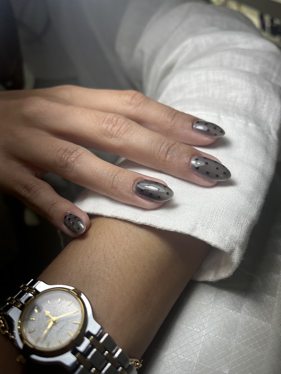 Unhas com poá preto sobre base translúcida